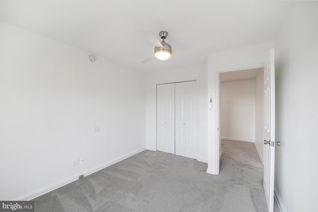 unfurnished bedroom featuring a closet, baseboards, carpet flooring, and ceiling fan