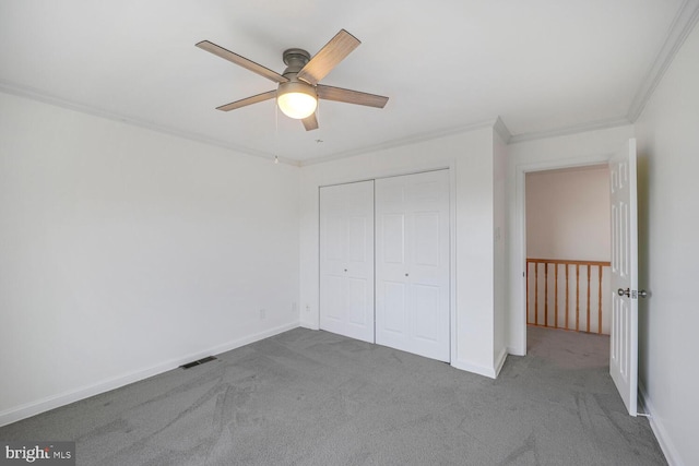 unfurnished bedroom with carpet, visible vents, a closet, and ornamental molding