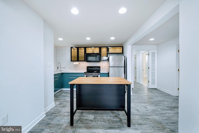 kitchen featuring wood counters, stainless steel appliances, recessed lighting, tasteful backsplash, and glass insert cabinets