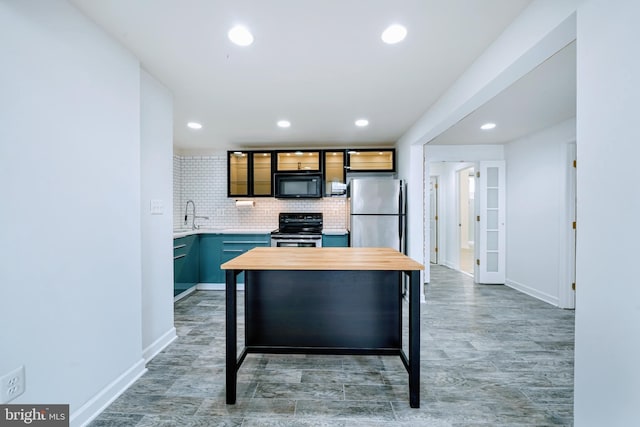 kitchen with glass insert cabinets, recessed lighting, wood counters, appliances with stainless steel finishes, and backsplash