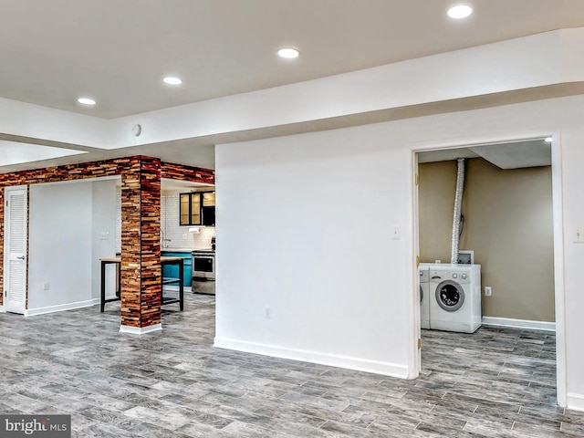interior space featuring baseboards, recessed lighting, wood finished floors, and washer and dryer