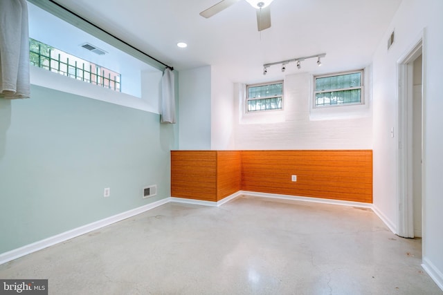 spare room featuring a ceiling fan, concrete floors, and visible vents