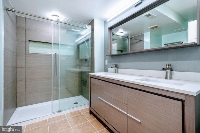 full bathroom with a sink, tile patterned flooring, double vanity, a shower stall, and visible vents