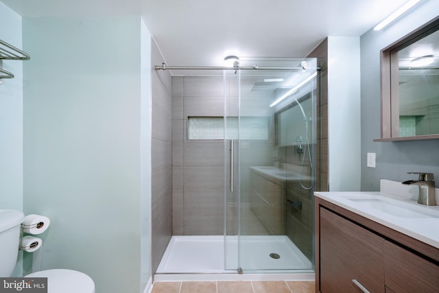 bathroom featuring vanity, tile patterned floors, toilet, and a shower stall