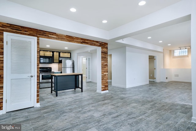 unfurnished living room with baseboards, recessed lighting, and light wood finished floors