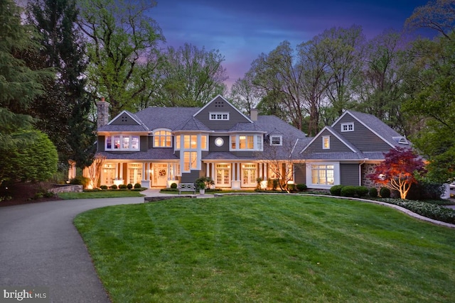 shingle-style home with a lawn, a chimney, and french doors