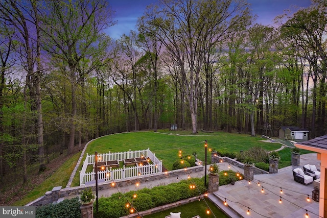 view of yard with an outbuilding, an outdoor fire pit, a patio area, and a wooded view