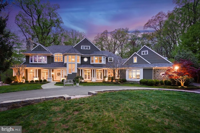 view of front facade featuring french doors, a chimney, and a yard