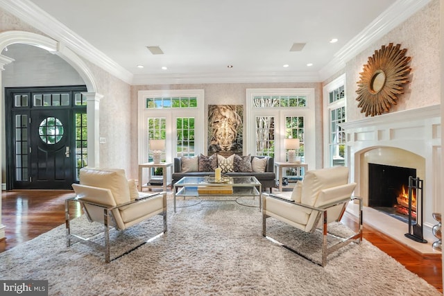 living room featuring arched walkways, french doors, wood finished floors, and a premium fireplace