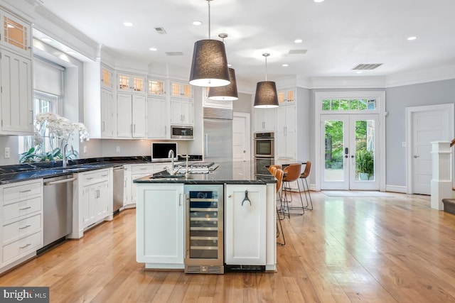 kitchen featuring built in appliances, plenty of natural light, wine cooler, and visible vents