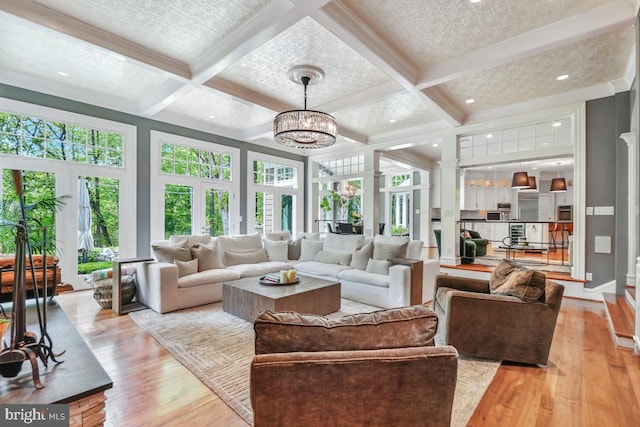 sunroom / solarium featuring an inviting chandelier, beamed ceiling, and coffered ceiling
