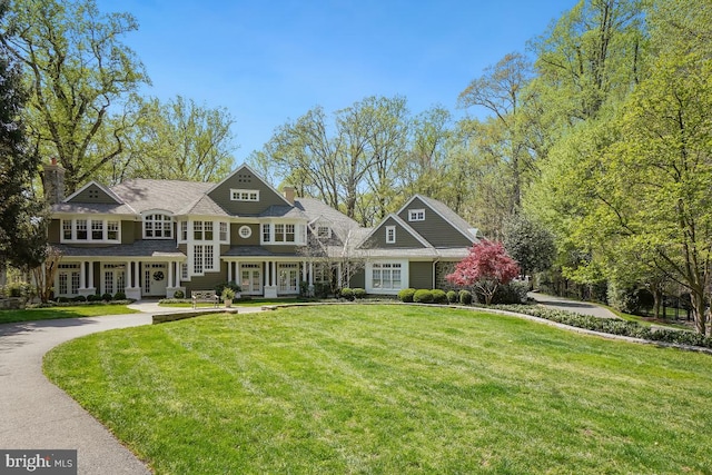 view of front of house with a front lawn, french doors, and a chimney