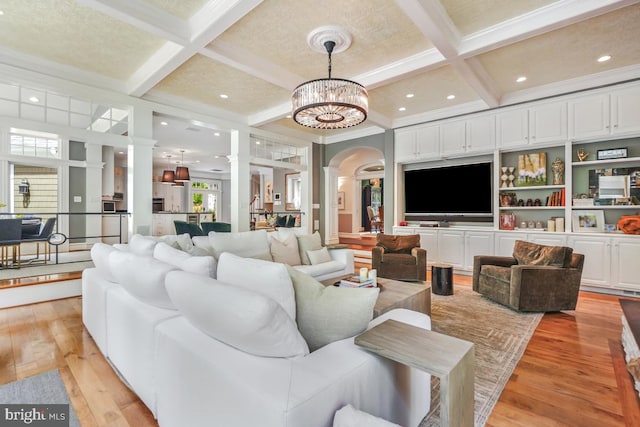living room with decorative columns, beam ceiling, light wood-type flooring, arched walkways, and coffered ceiling