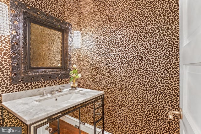 bathroom with vanity and wallpapered walls