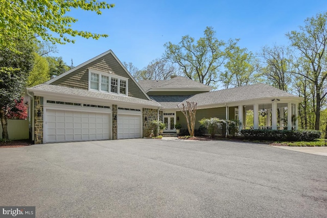 view of front of house featuring french doors, an attached garage, roof with shingles, and aphalt driveway
