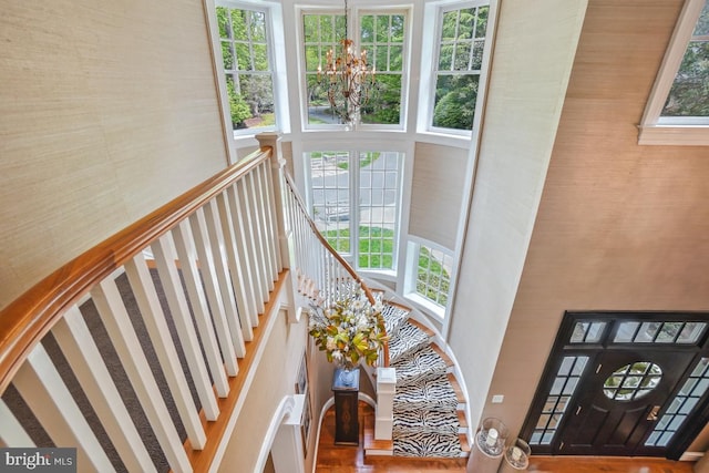 stairway with a notable chandelier and a towering ceiling
