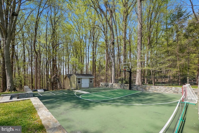 view of sport court with fence, a storage shed, and basketball court