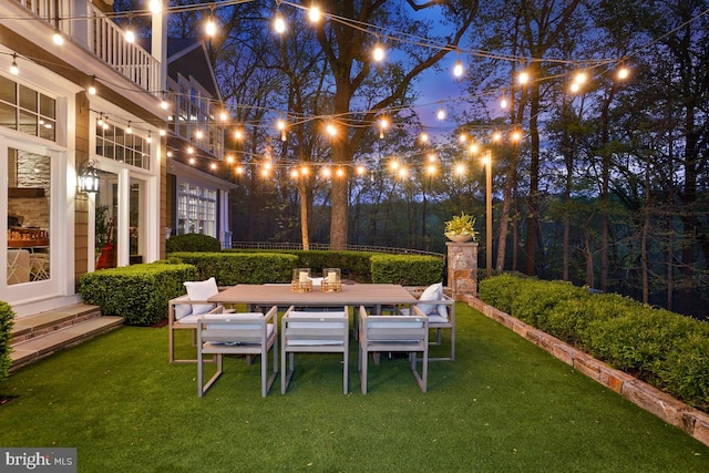 yard at night featuring outdoor dining space