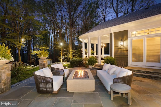 patio at twilight with an outdoor living space with a fire pit