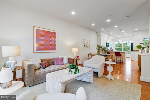 living area featuring light wood-style flooring, recessed lighting, and baseboards