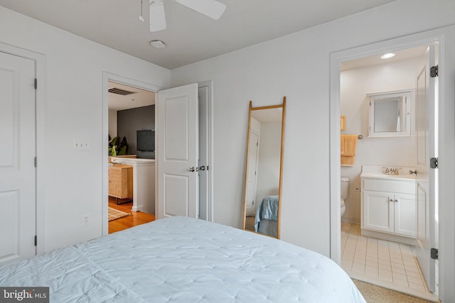 bedroom with connected bathroom and light tile patterned floors