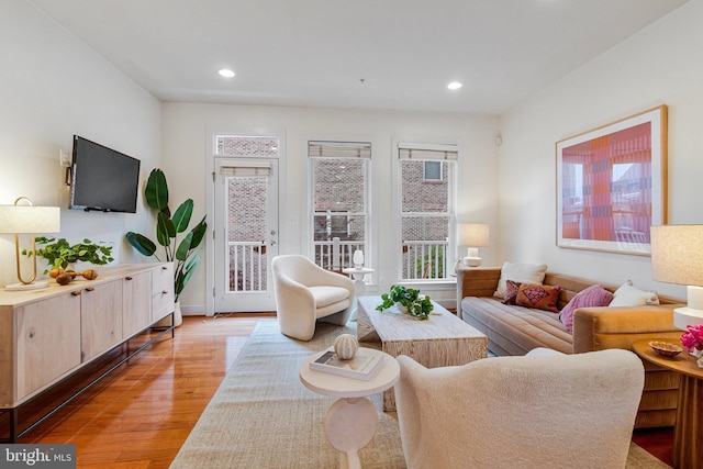 living area with light wood finished floors, healthy amount of natural light, and recessed lighting