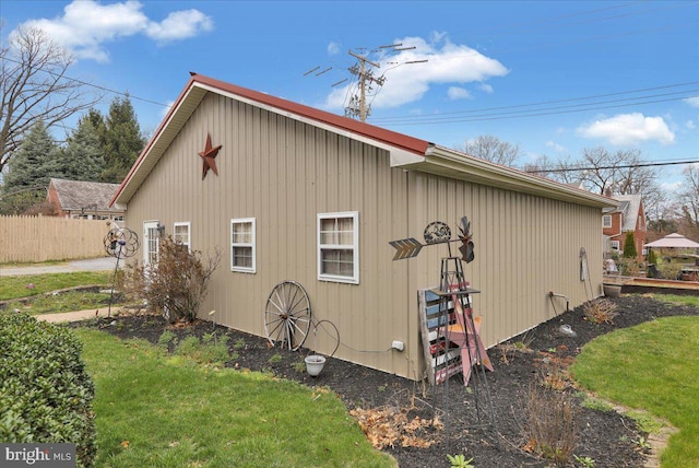 view of property exterior with a yard and fence