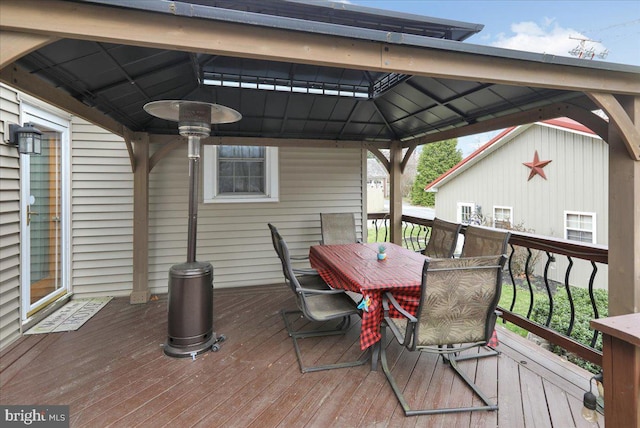 wooden terrace featuring a gazebo and outdoor dining area