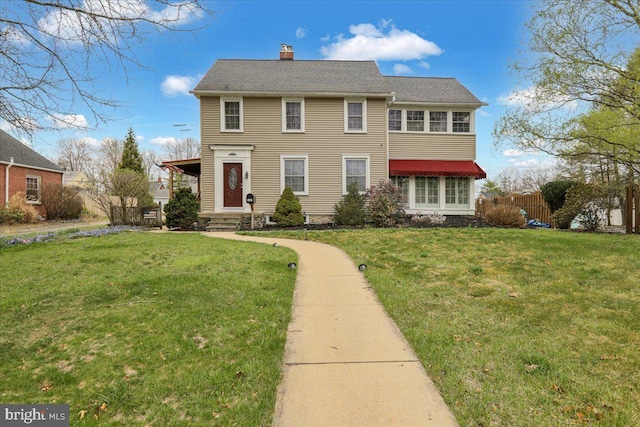 view of front of house featuring a front yard, entry steps, and a chimney