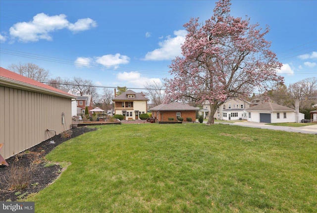 view of yard with a residential view and a garage