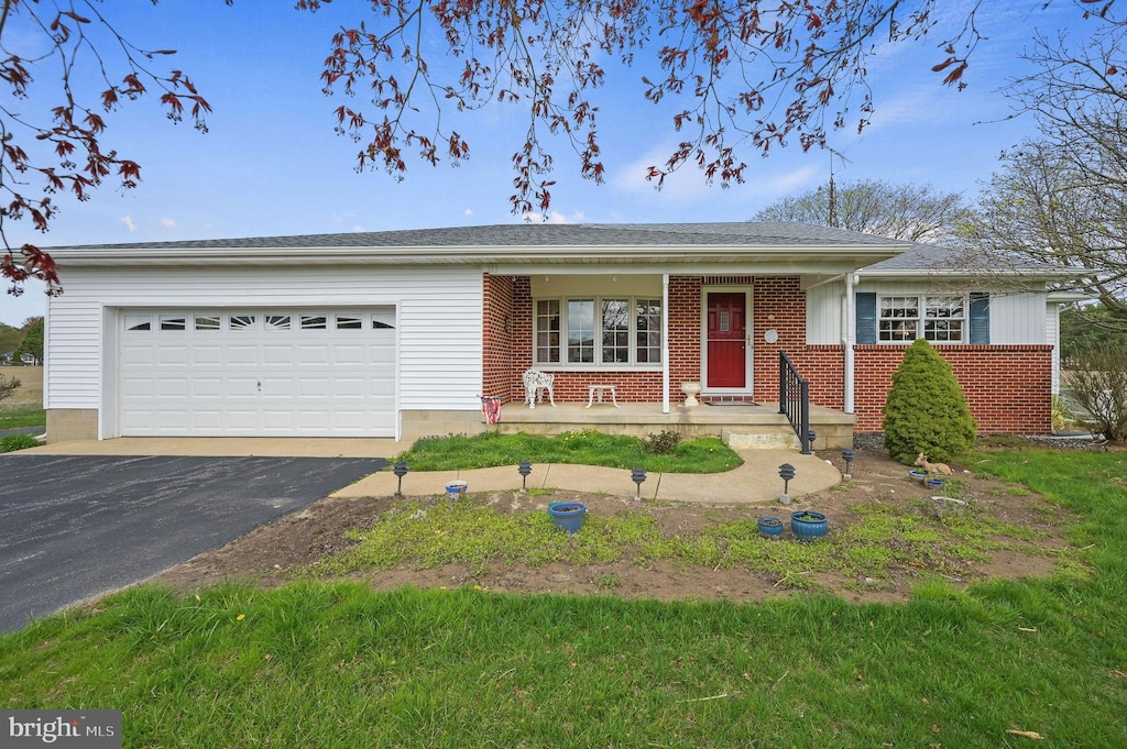 328 Moose Lodge Rd, Camden Wyoming, DE 19934 - ranch-style house featuring an attached garage, driveway, brick siding, and a porch