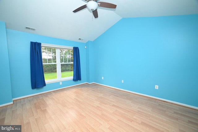 spare room with light wood-style floors, visible vents, vaulted ceiling, and ceiling fan