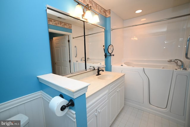 bathroom featuring vanity, visible vents, a wainscoted wall, toilet, and tile patterned floors