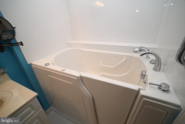 bathroom with a bath, vanity, and tile patterned floors