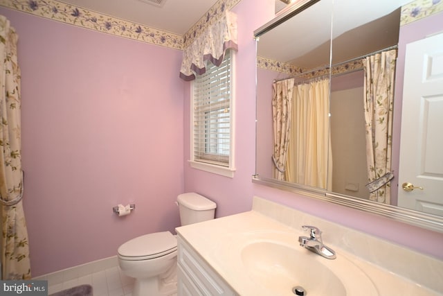 bathroom featuring toilet, vanity, baseboards, and tile patterned flooring