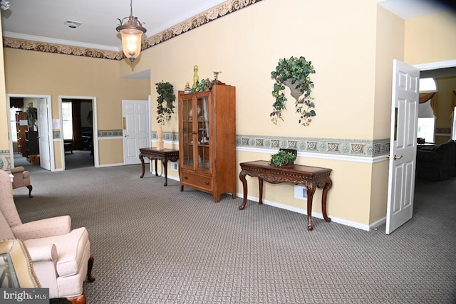 sitting room with carpet, a wealth of natural light, baseboards, and ornamental molding