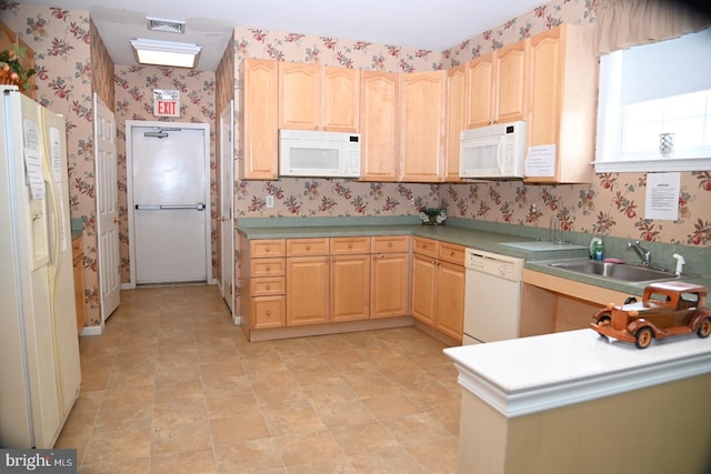 kitchen with wallpapered walls, visible vents, light brown cabinets, a sink, and white appliances