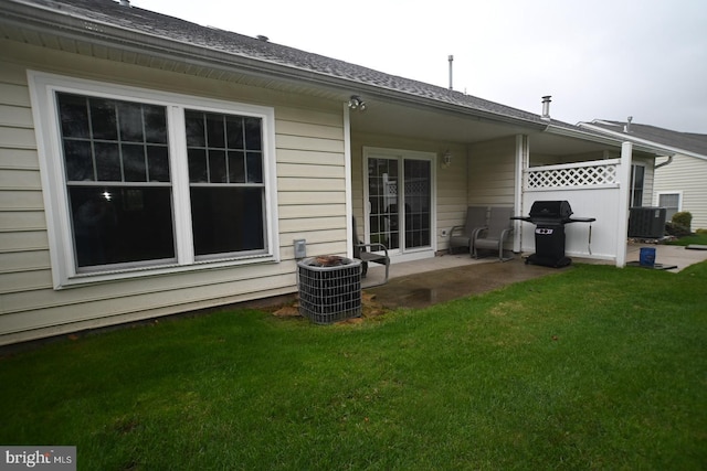 rear view of property featuring a patio, cooling unit, and a lawn