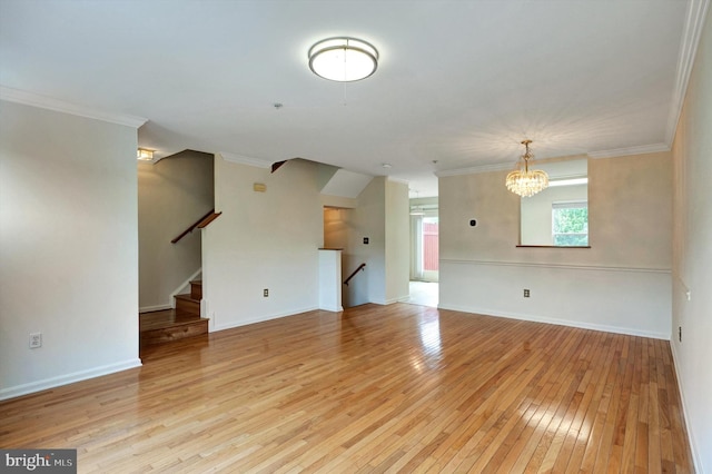 unfurnished living room featuring light wood-type flooring, baseboards, ornamental molding, and a notable chandelier