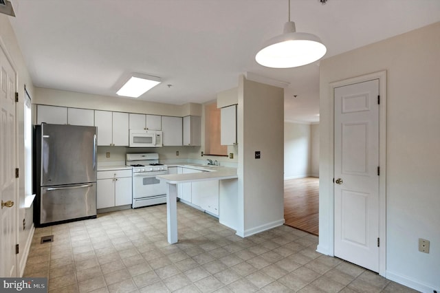 kitchen with a sink, white appliances, baseboards, decorative light fixtures, and light countertops