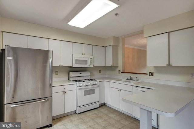kitchen featuring white cabinetry, white appliances, light countertops, and a sink