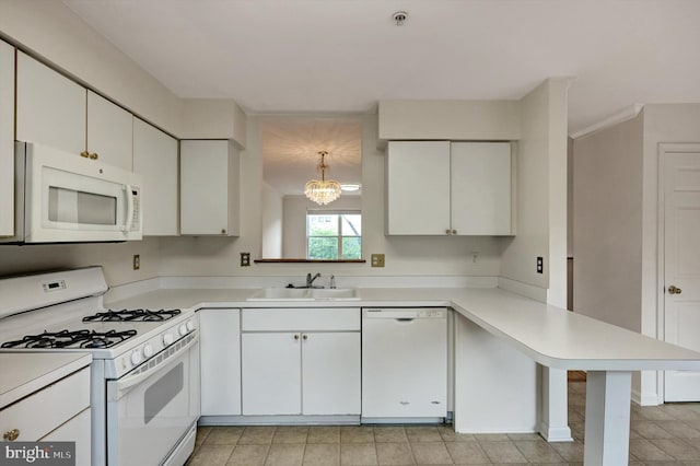 kitchen with a sink, a peninsula, white appliances, and light countertops
