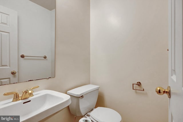 half bathroom featuring a sink and toilet