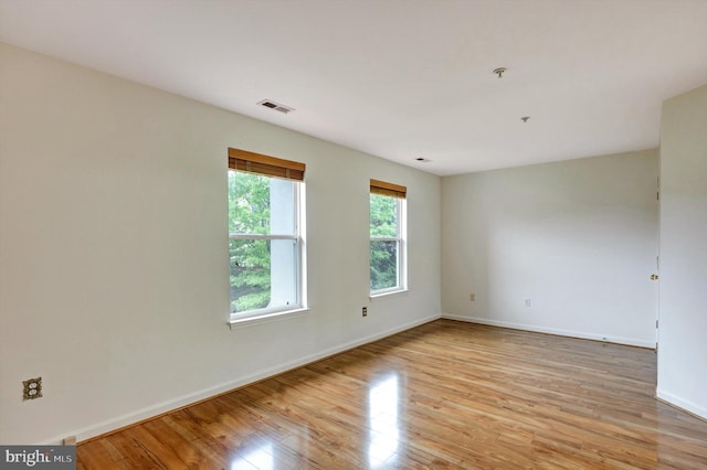 empty room with baseboards, light wood-style flooring, and visible vents
