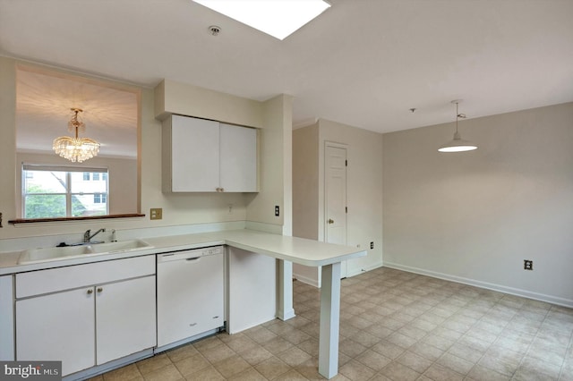 kitchen with a peninsula, a sink, white cabinetry, light countertops, and white dishwasher
