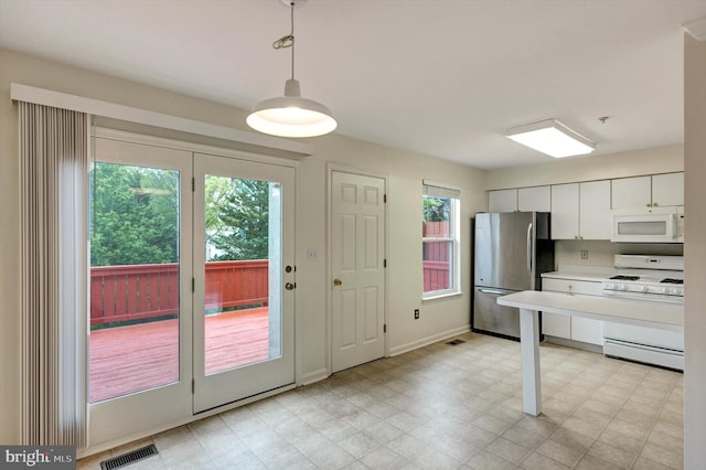 kitchen with white appliances, visible vents, pendant lighting, light countertops, and white cabinets