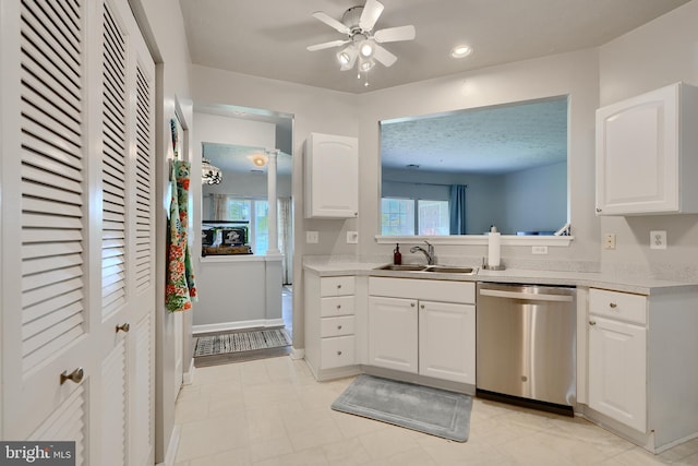 kitchen with ceiling fan, a sink, dishwasher, light countertops, and white cabinetry