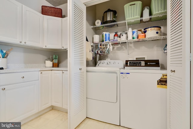 clothes washing area with light tile patterned flooring and washer and dryer
