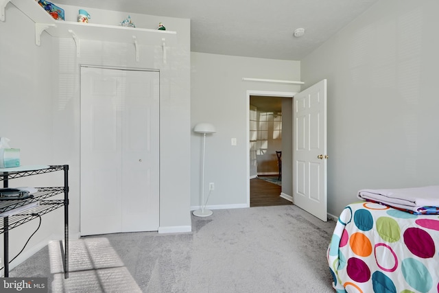 bedroom featuring carpet flooring, baseboards, and a closet