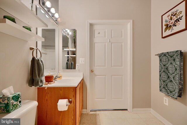bathroom with vanity, tile patterned flooring, baseboards, and toilet